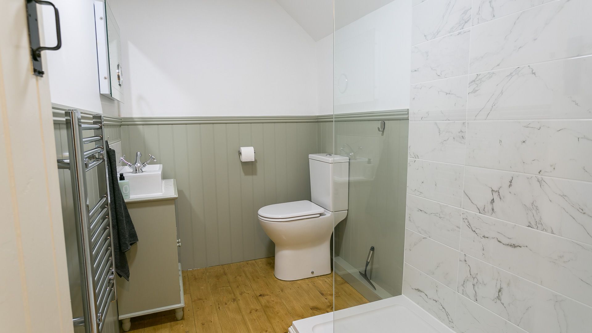 Une petite salle de bain comprenant des toilettes, un lavabo et un espace douche.