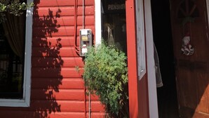 A red building with a sign that reads "Cruzes" and a number "144" on the front. - Hostal Riberas del Cruces  (Mariquina)