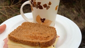 A sandwich on a plate with a cup of coffee. - Hostal Riberas del Cruces  (Mariquina)