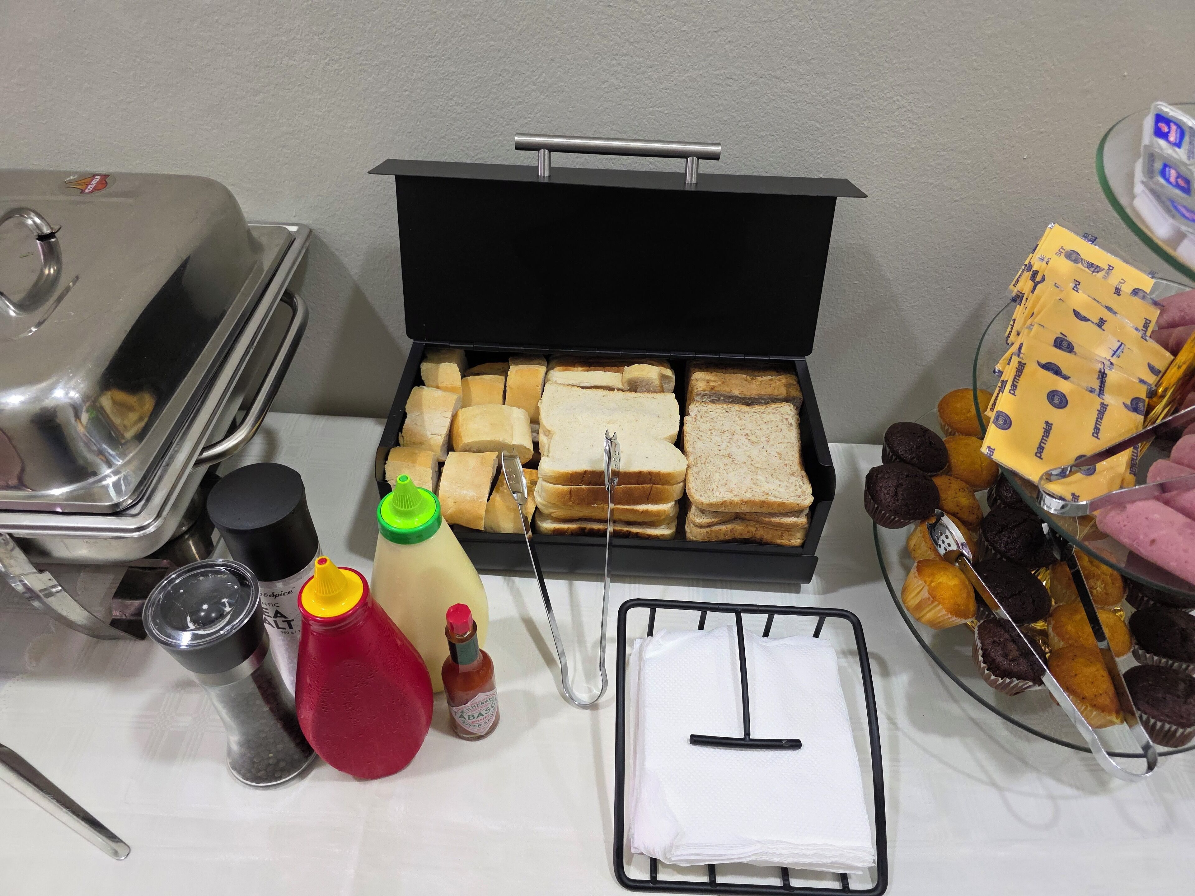 Un buffet proposant une variété de plats, d’assaisonnements et d’ustensiles.