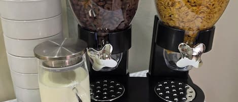 Una máquina de café con dos dispensadores, uno de chocolate y otro de copos de cereales.