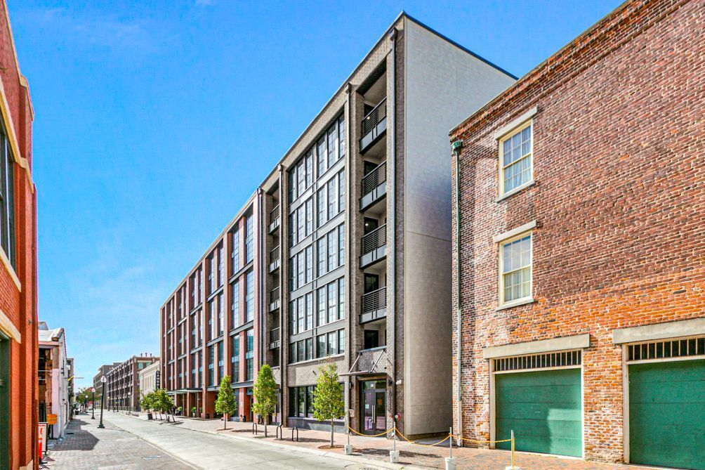 Un edificio moderno con varios pisos, ventanas amplias y fachada de ladrillo.