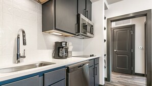 A modern kitchen with stainless steel appliances, a dishwasher, and a coffee maker.