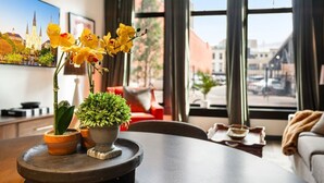 Een eettafel met planten in potten en een lijst met foto aan de muur.