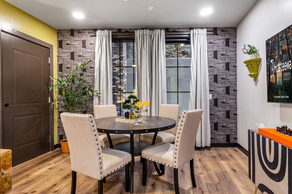 Un comedor con una mesa redonda, cuatro sillas y un adorno decorativo.
