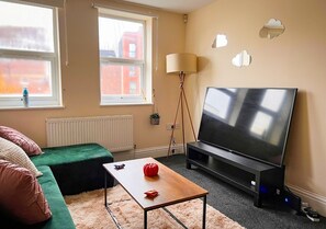 Cozy retreat with a single bed, flat-screen TV, and a small table.