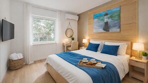 A modern hotel room with a large bed, a flat-screen TV, a desk, and a painting of a lighthouse. - B&B Trieste Sea Life (Trieste)