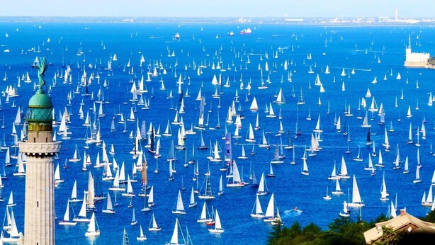 A large body of water with numerous sailboats, a prominent tower, and a distant cityscape. - B&B Trieste Sea Life (Trieste)