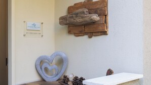 A reception area with a wooden wall decor, a heart-shaped sculpture, and a signboard. - B&B Trieste Sea Life (Trieste)
