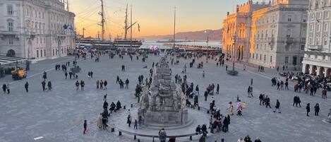 Une vaste place ouverte, avec un monument central, entourée de bâtiments historiques.