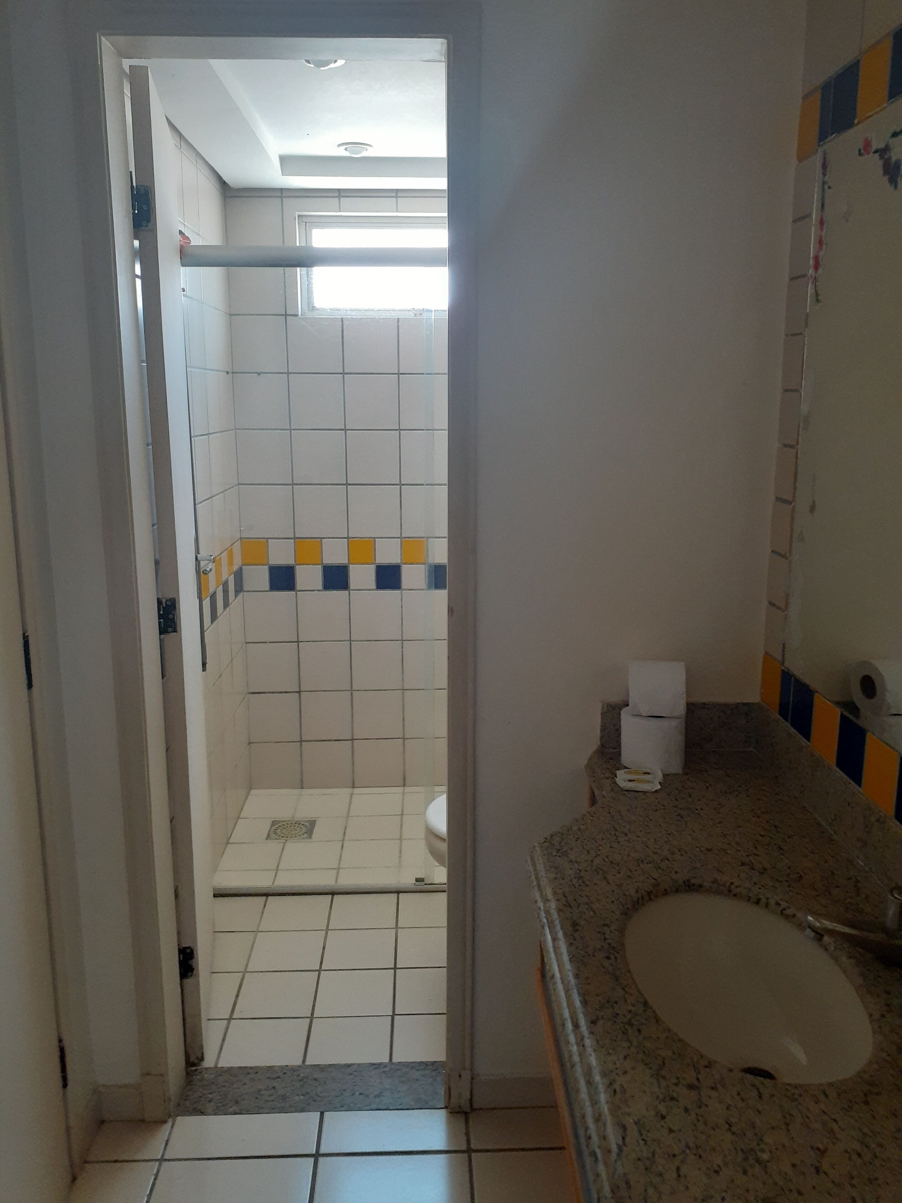 A bathroom with a shower, toilet, and sink.