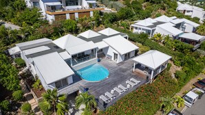 Un complexe résidentiel moderne comprenant plusieurs maisons, une piscine à usage collectif et de nombreux espaces verts.