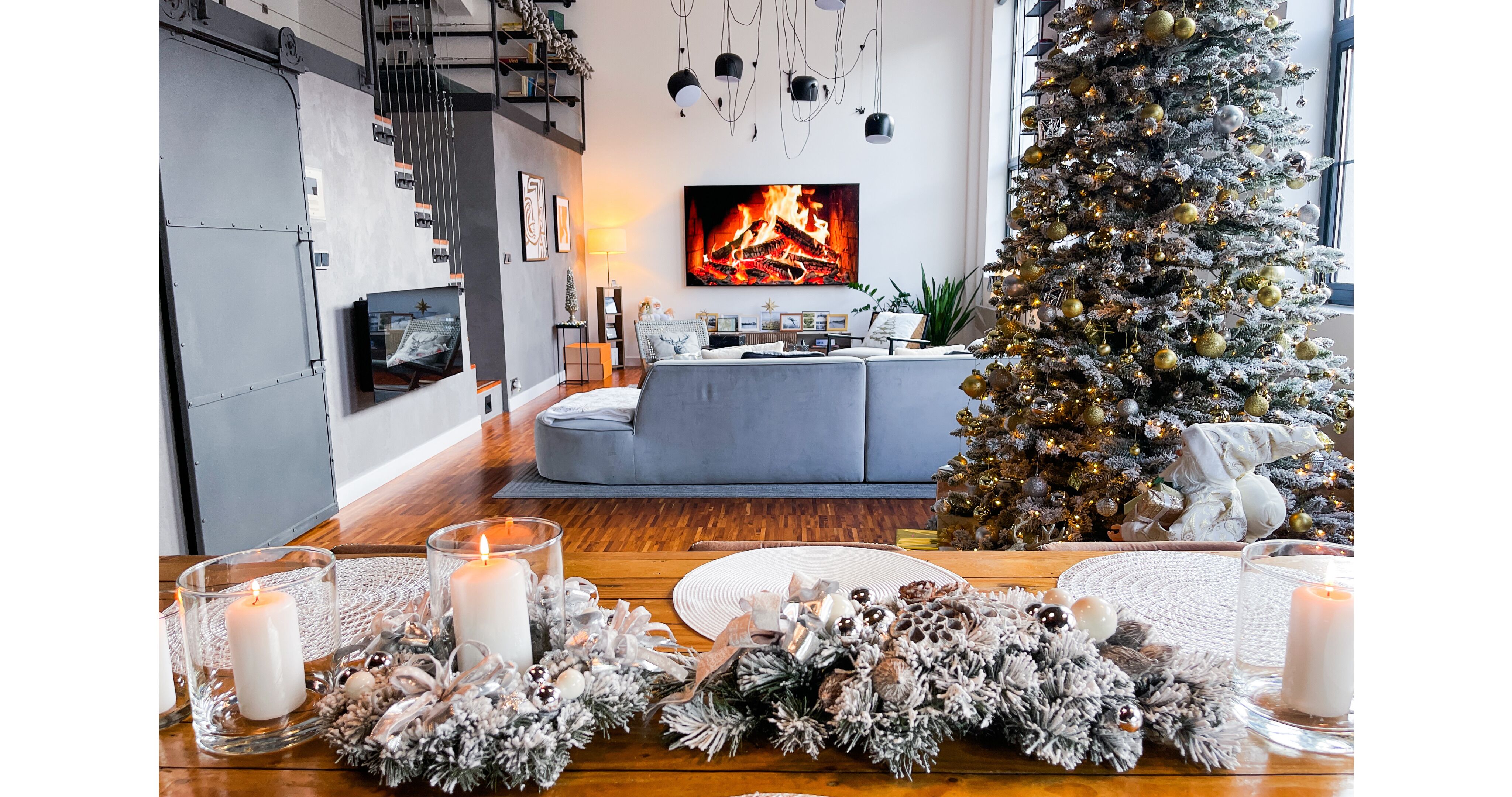 Una sala de estar moderna con un gran árbol de Navidad, una chimenea y una zona de estar acogedora.