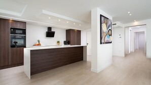Una cocina moderna con una isla central, horno empotrado y microondas.