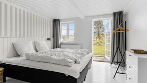 A bedroom with a bed, a radiator, a window, and a view of the outdoors. - Cozy home in Sydals with sauna (Sydals)