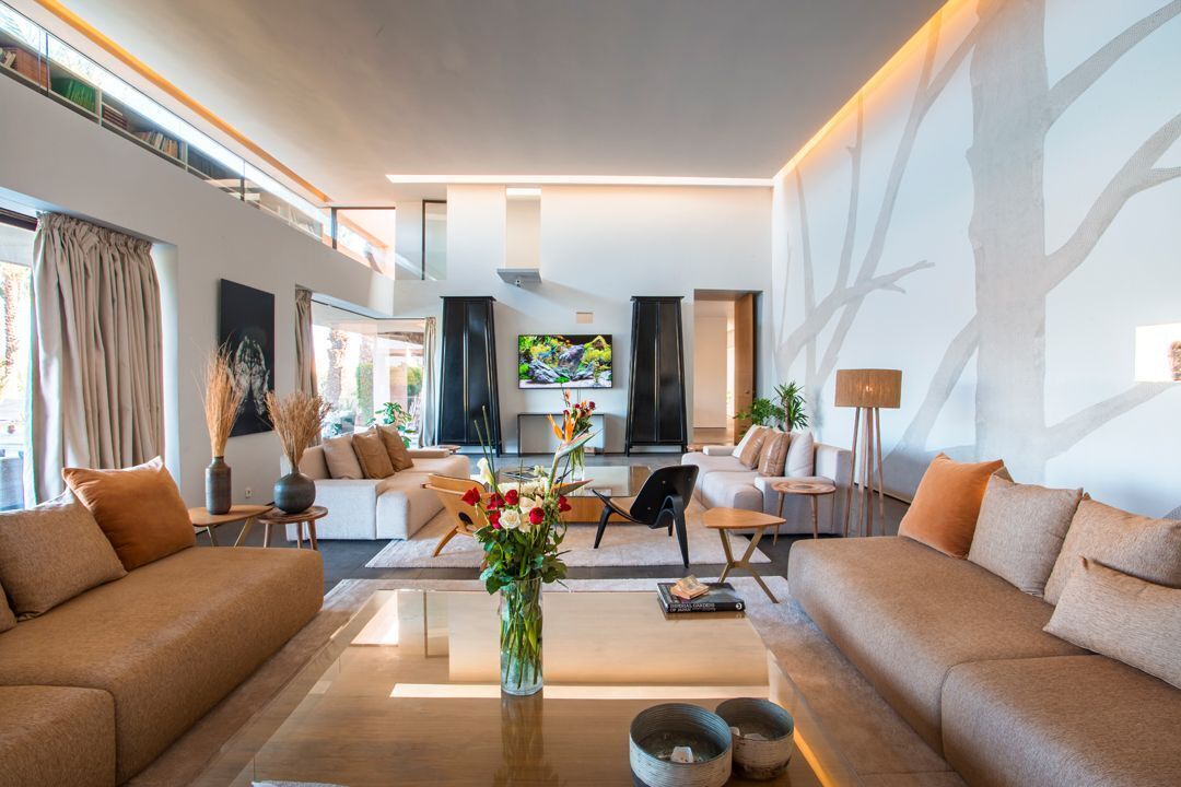 Un salon moderne avec un canapé, une table basse et un téléviseur.