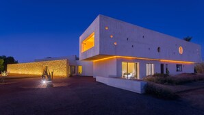Edifici modern amb teulada plana, grans finestres i entrada ben il·luminada.