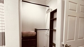 Un couloir étroit avec un escalier en bois menant à un palier.