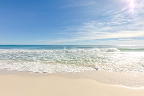 A beach with clear blue water and a sandy shore. - COZY CONDO ~ Steps away from the beach! Perfect for families and groups! (Gulf Shores)