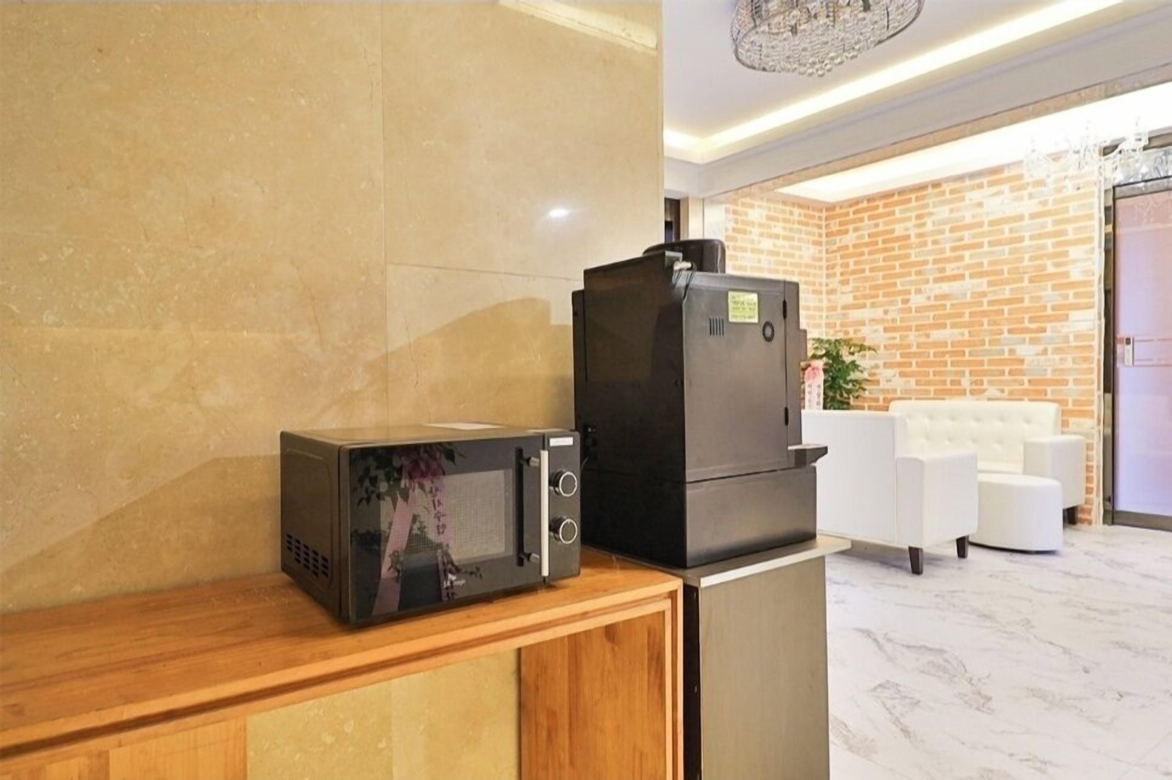 Una cocina con microondas y refrigerador sobre una encimera de madera.