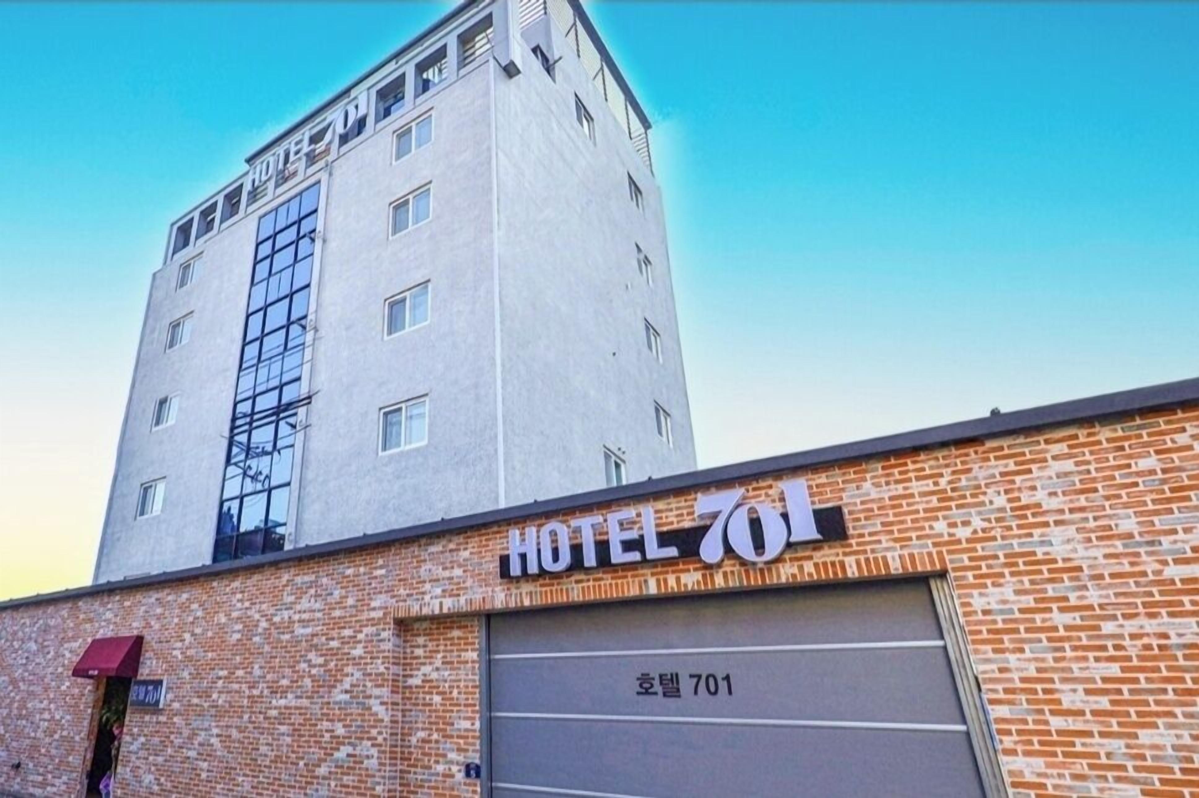 Un hôtel avec une façade en briques et un grand portail de garage.