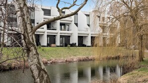 Un bâtiment moderne doté d’un toit plat, de grandes fenêtres et d’une cour avec un bassin.