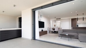 A modern kitchen with dark cabinetry and a large window.