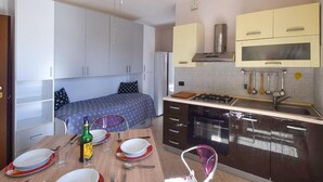 Una cocina compacta con comedor, una cama y un refrigerador pequeño.