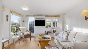 A cozy living room with a wicker chair, a white sofa, and a wooden coffee table.
