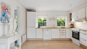 A modern kitchen with white cabinets, a wooden countertop, and a built-in oven. - Amazing home in Sunds with lake view (Sunds)