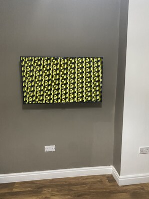 Une pièce avec un mur gris et un plancher en bois.
