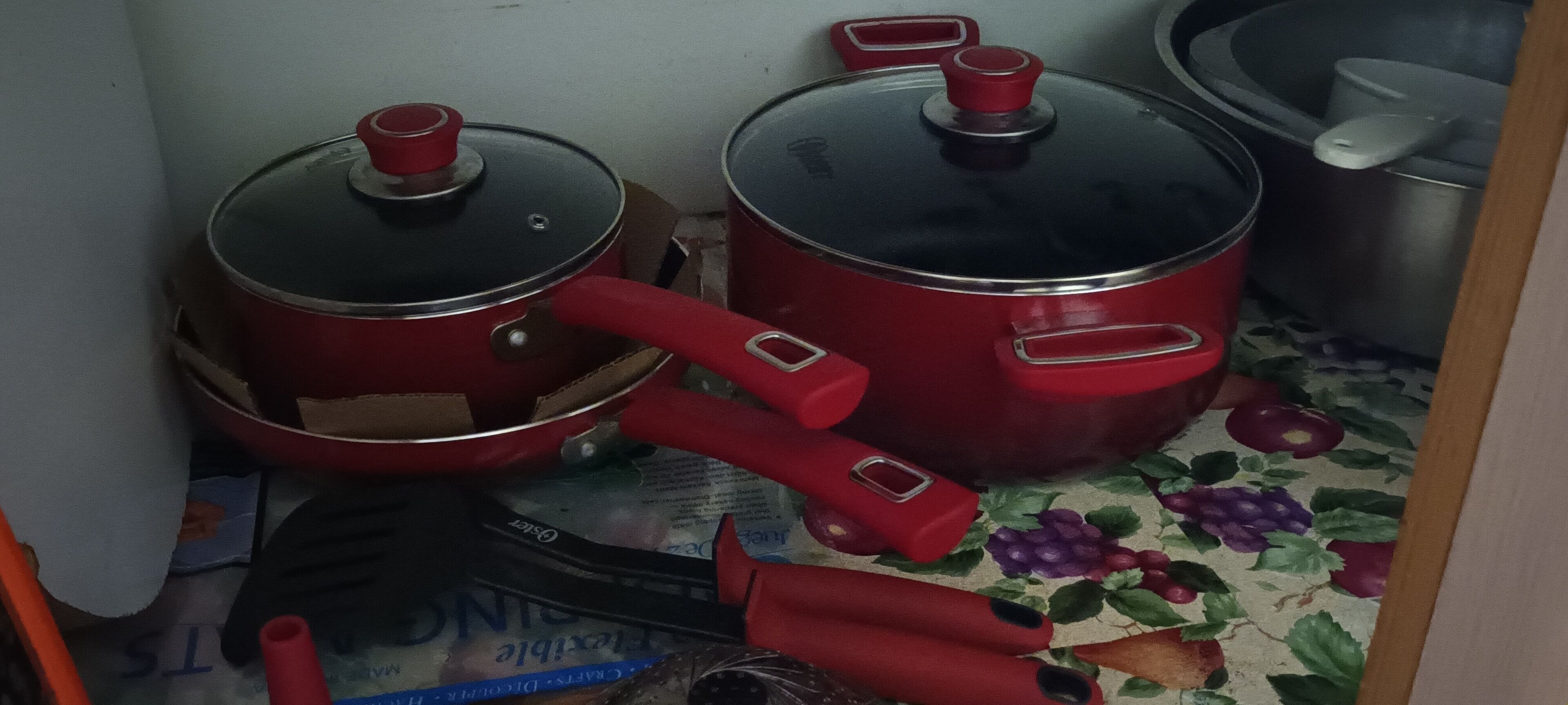 Dos ollas rojas con tapas sobre una encimera de cocina.