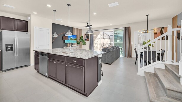 A modern kitchen with a central island, built-in appliances, and pendant lighting. - Windsor Island Dream | 5BR, 4.5 Bath Cozy Escape w/ Private Pool and Themed Kids' Rooms Near Disney (Davenport)