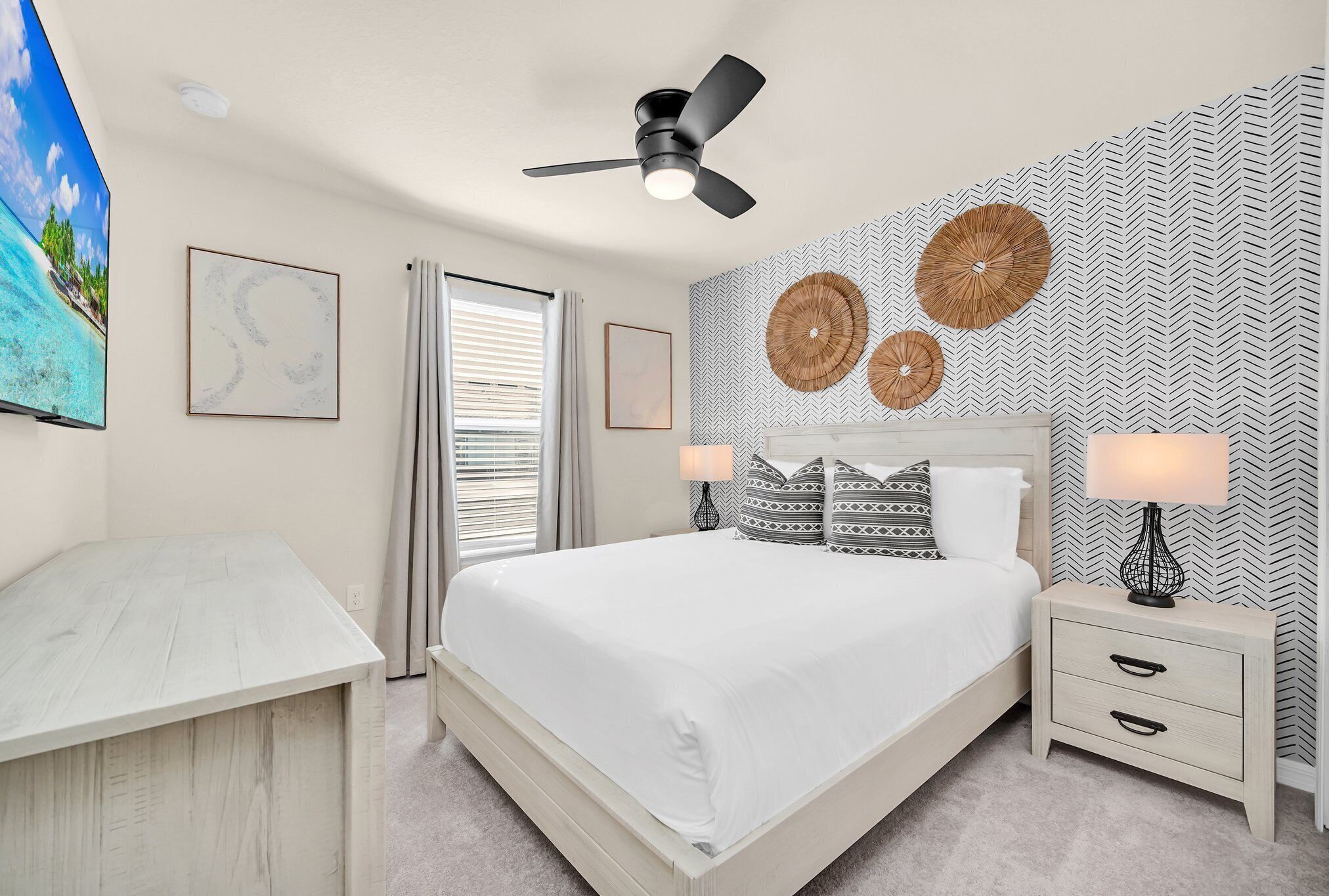 Un dormitorio con cama, mesitas de noche, ventilador de techo y decoración mural.