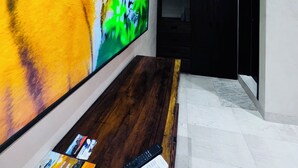 Un couloir moderne avec un grand téléviseur à écran plat fixé au mur, sur lequel est affiché un tigre.