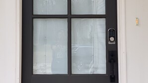 A black-framed door with frosted glass panels and a keypad lock. - Cozy Southern Retreat, 4 Spacious Bedrooms, Massage Chair, 8 Mins to Ole Miss (Oxford)