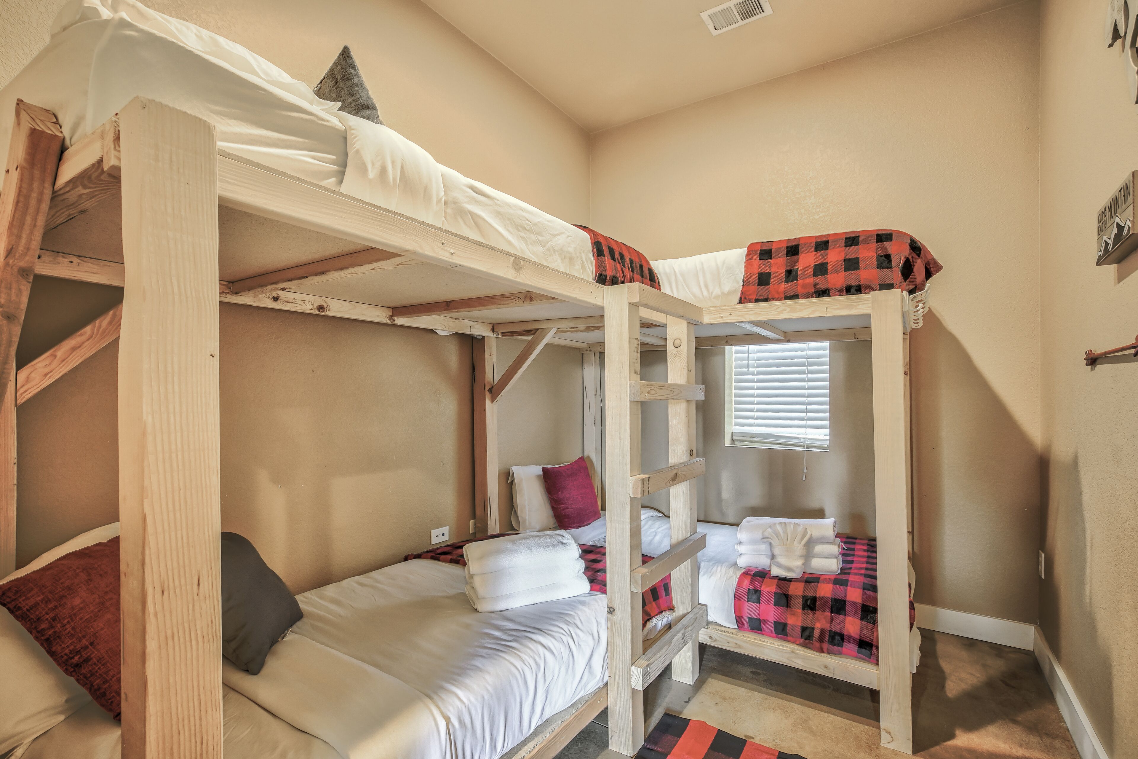 A bunk bed room with two beds, each with pillows and blankets.