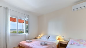 A bedroom with a bed, bedside tables, a lamp, and an air conditioning unit. - Apartment Ana by Interhome (Starigrad-Paklenica)
