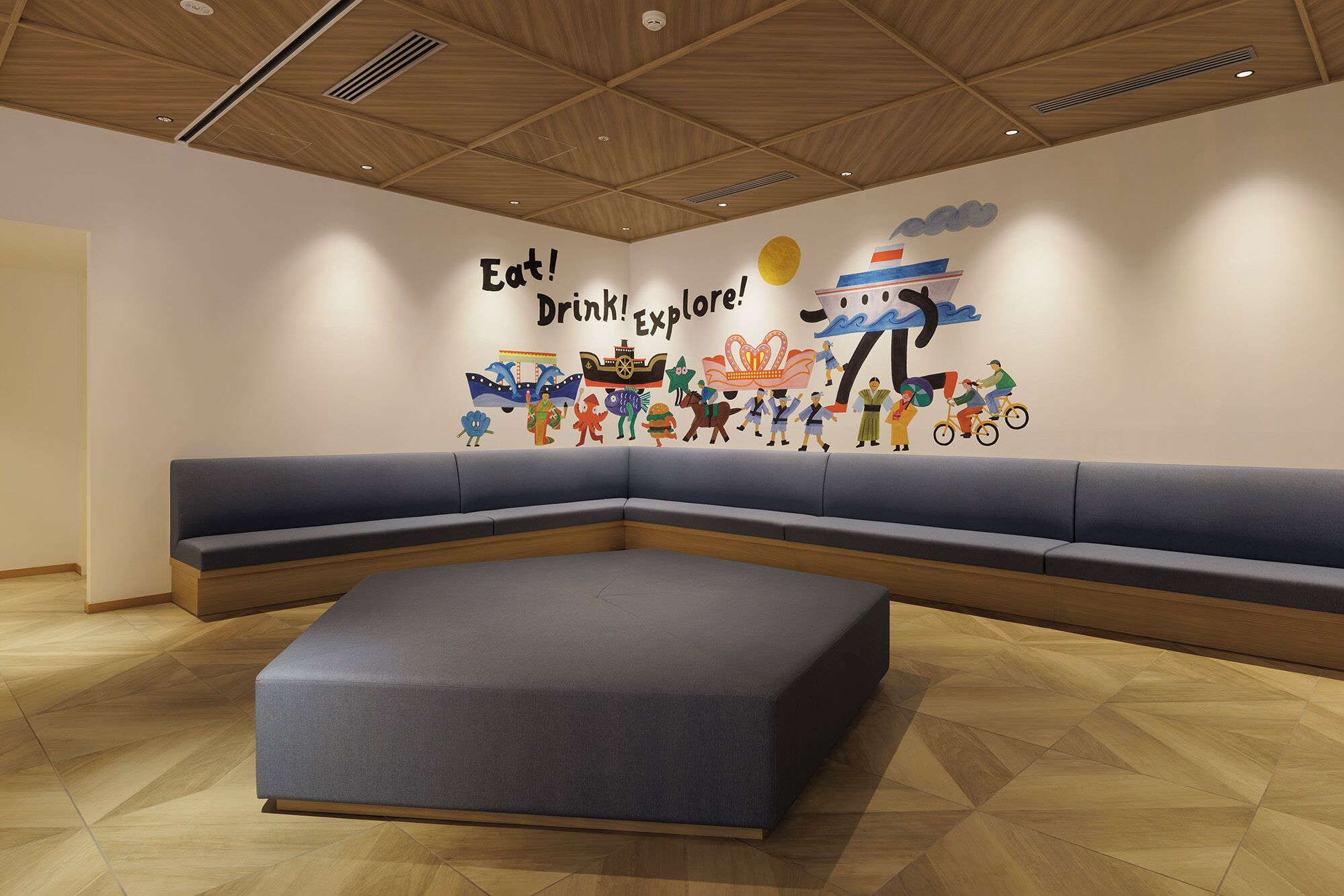 A modern waiting area with a large wall mural, a grey sofa, and a wooden ceiling.