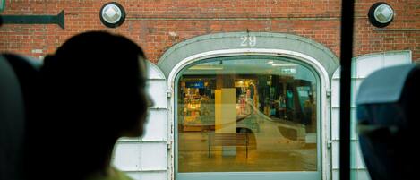 A bus stop with a brick wall and a number 29 sign.