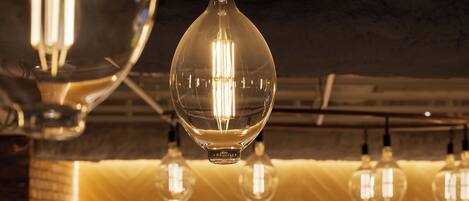 A modern interior with hanging spherical light fixtures and a brick wall.