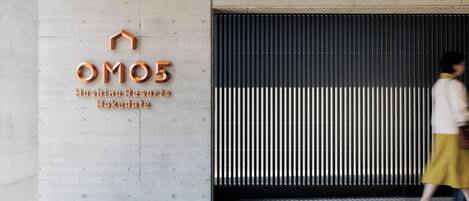 Entrada de un hotel con un cartel que dice "OM05 Hoshoino Resorts Hakodate".