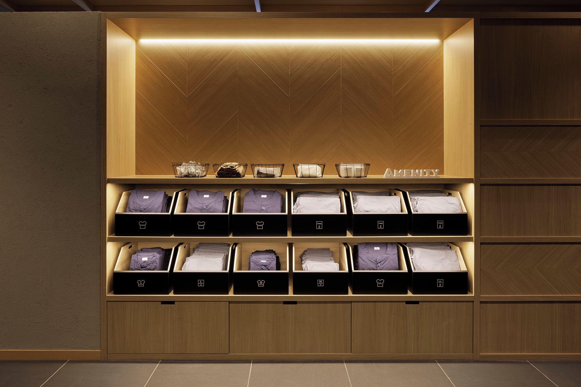 A neatly organized storage area with multiple compartments for folded clothes, each labeled with a different category.