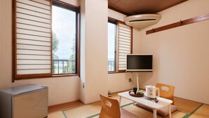 A room with tatami mats, a television, a small table with a kettle, and a refrigerator. - Hayamasou (Tokamachi)