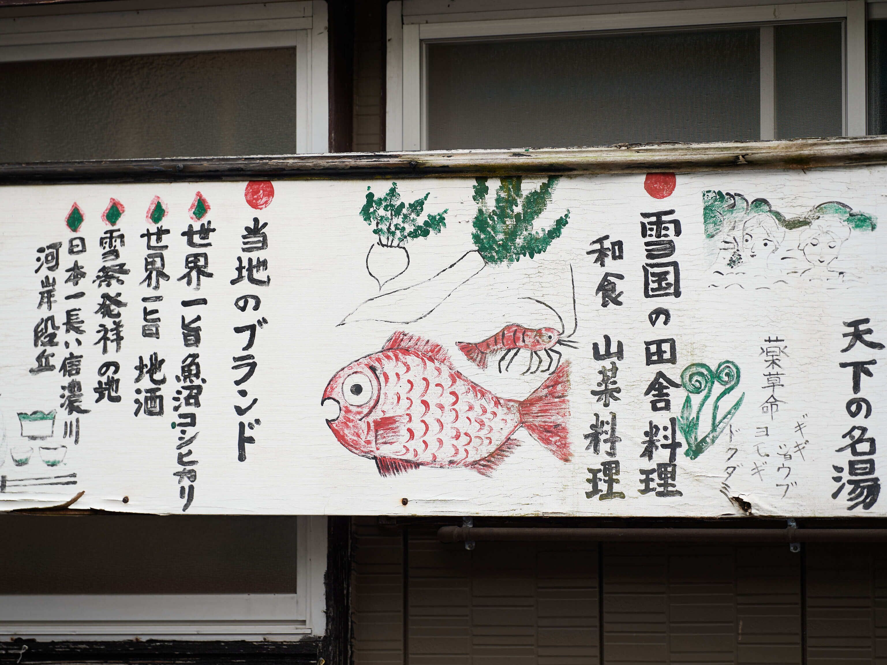 A sign with Japanese text and illustrations of a fish and a plant.