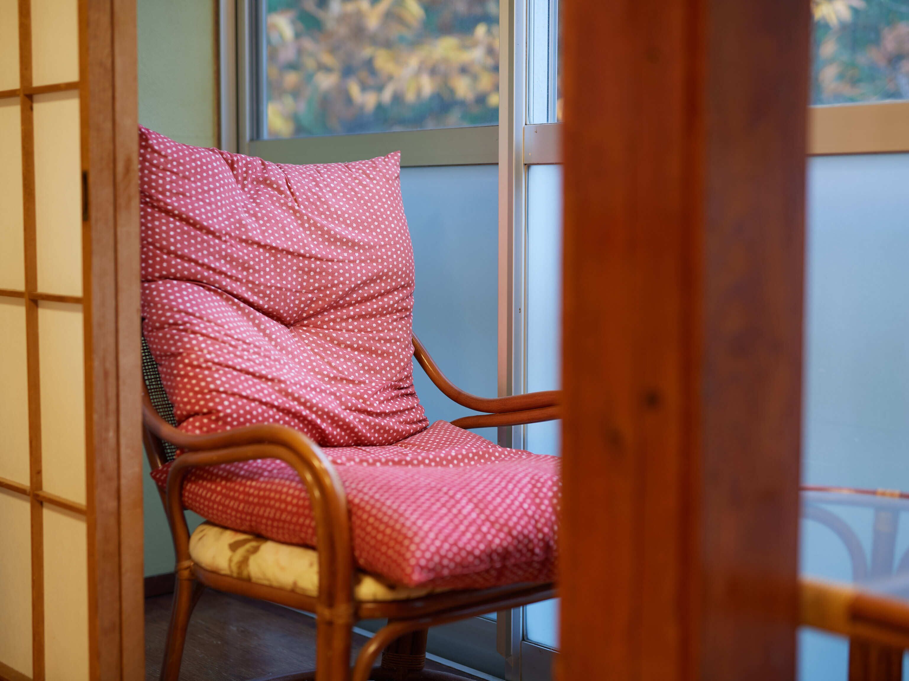 A corner room with a wooden chair and a window.