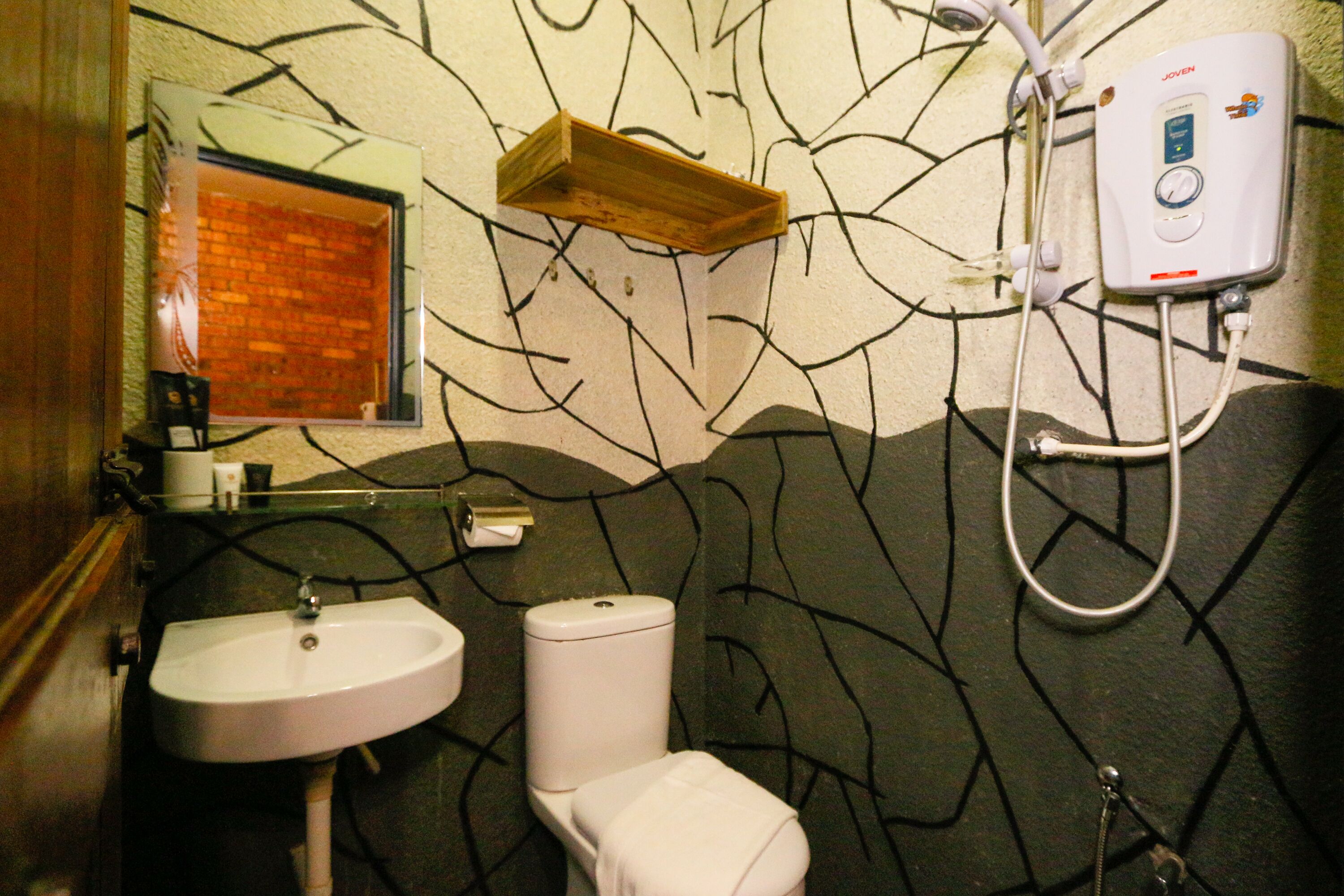 Un baño con lavamanos, inodoro y cabina de ducha blancos.