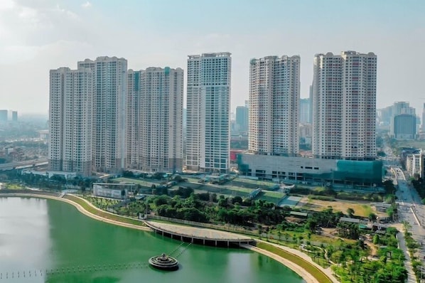 A high-rise residential building complex with multiple towers, a central water feature, and surrounding greenery.