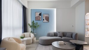 Una sala de estar moderna con un sofá modular, una mesa de centro redonda y un diseño minimalista.