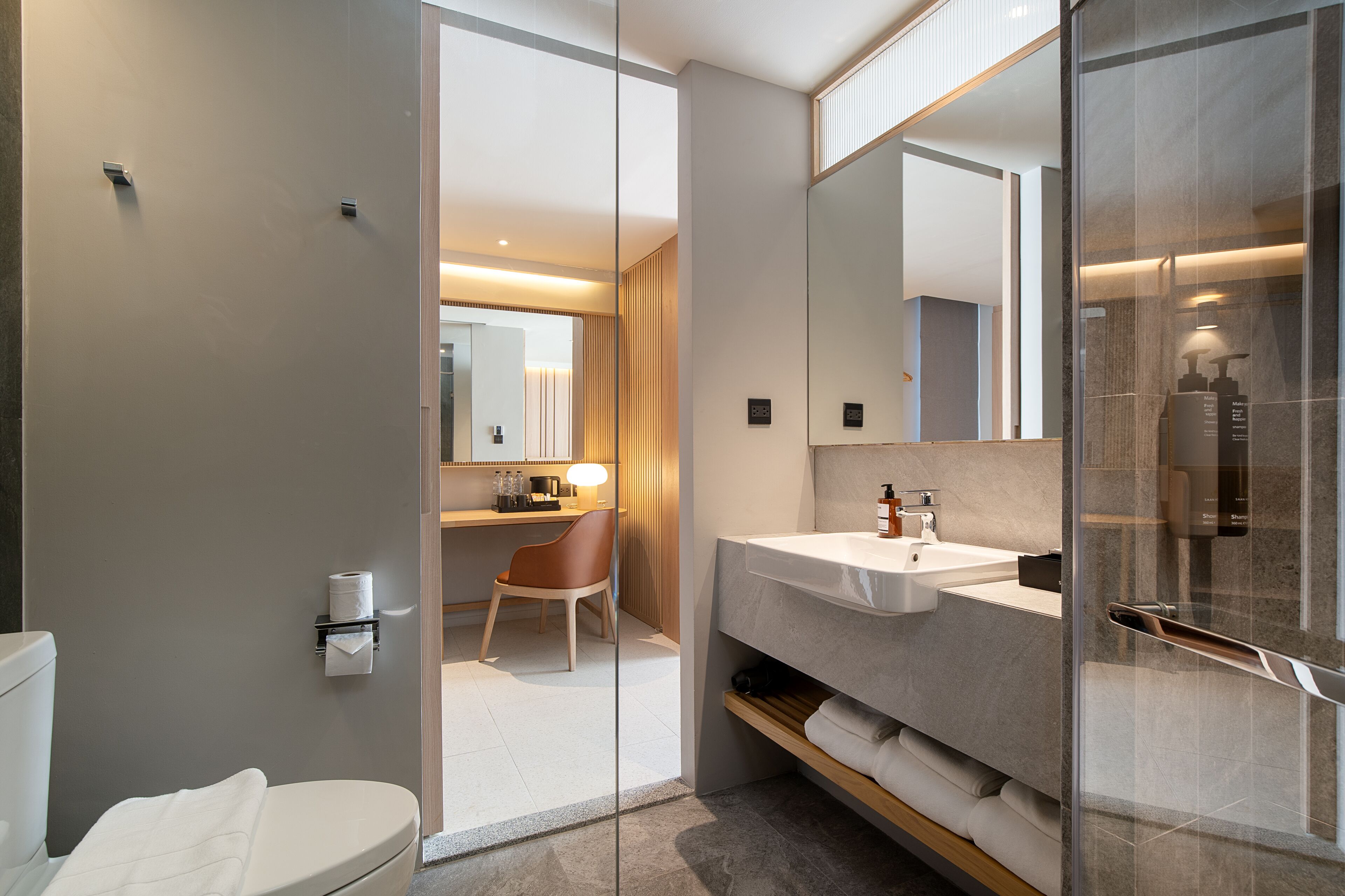 Un baño moderno con inodoro, lavabo y zona de ducha.